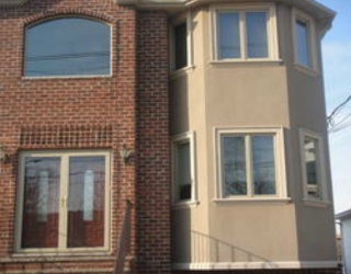 stucco and brick house exterior installed by pavers